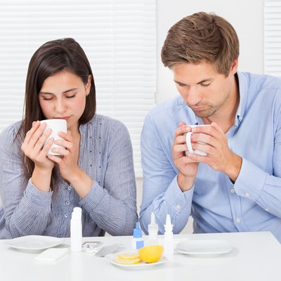 Sick Couple Drinking Lemon Tea At Table