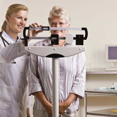 Doctor weighing senior woman