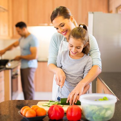 young family preparing meal in kitchen