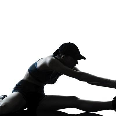 woman runner jogger stretching legs warming up silhouette