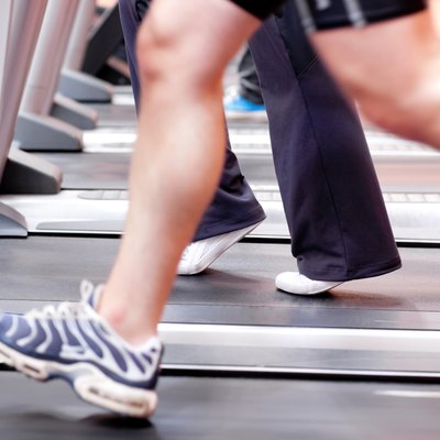 Close-up of the legs of an athletic young woman exercising on a running machine