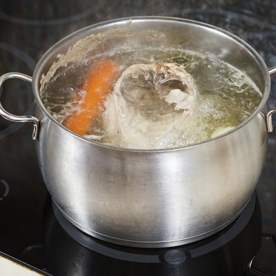 simmering chicken soup with seasoning vegetables