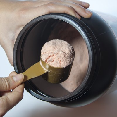 Man taking scoop of protein from black container