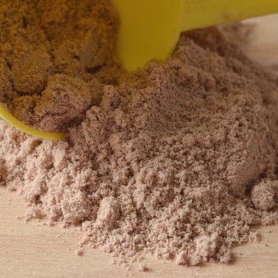 Chocolate protein powder spilled from yellow scoop