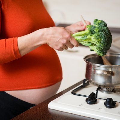 Pregnant woman cooking broccoli