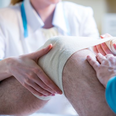 Nurse rewinding knee bandage