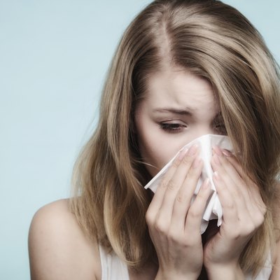 Flu allergy. Sick girl sneezing in tissue. Health