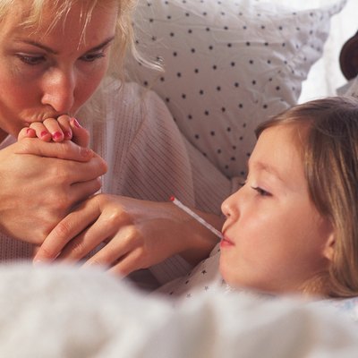 Mother kissing sick daughter's hand