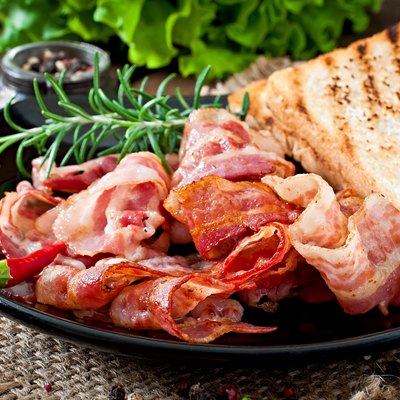 Fried bacon and toast on a black plate