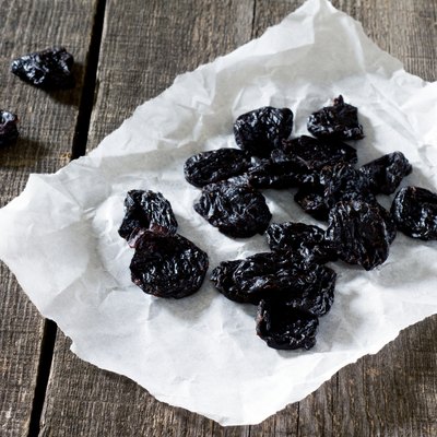 Dried plums on a dark background in a rustic style.