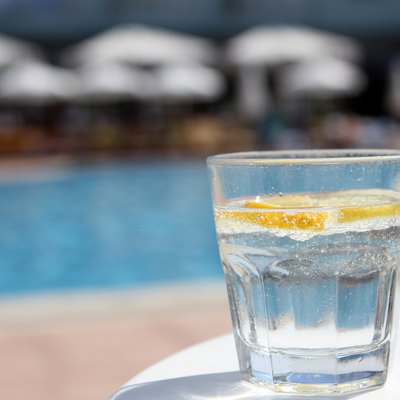 Fresh water with lemon cocktail near pool on the table