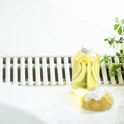 Bath oil and a bath sponge next to hot tub