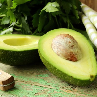 ripe avocado cut in half on a wooden table