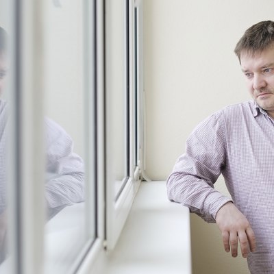 Man looking at snow into the window
