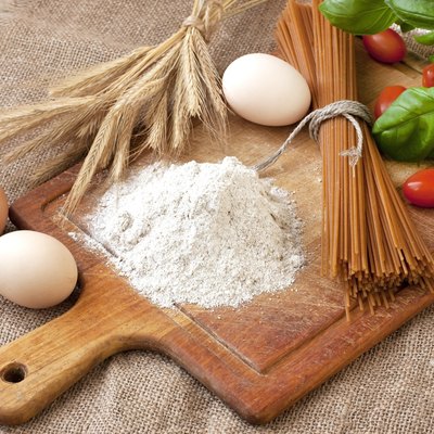 Raw pasta and ingredients on the wooden board
