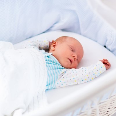 Cute newborn baby in white bed