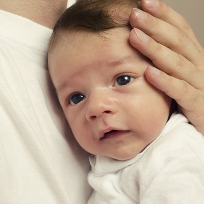Father's hands holding his newborn with love,