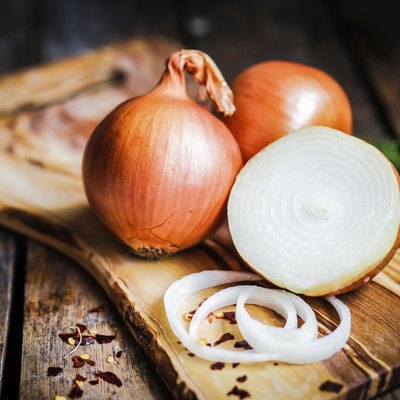Golden onions on rustic wooden background