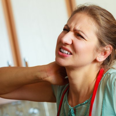 Overworked woman suffering from neck pain.