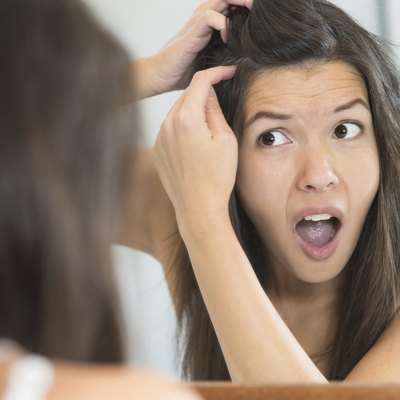 Horrified young woman looking in the mirror