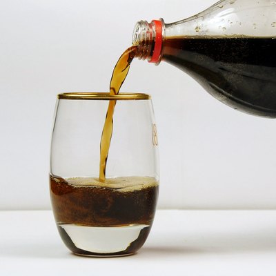Pouring soda from the bottle into a glass
