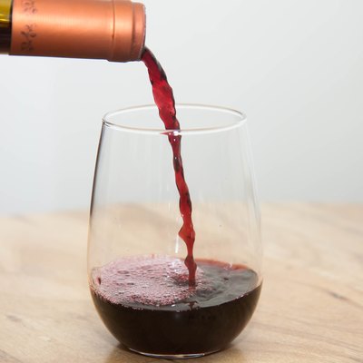 Pouring red wine into a stemless glass