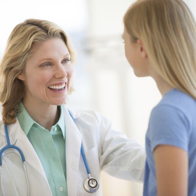 Female Doctor Looking At Girl In Clinic