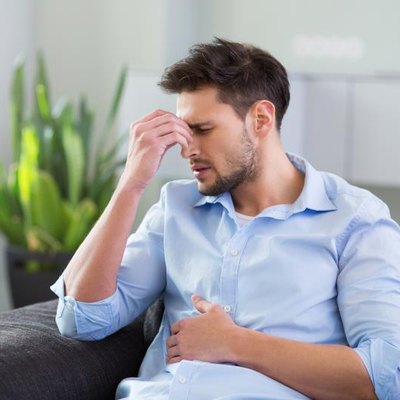 Man On Sofa Having Headache