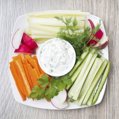 vegetable assortment and sauce with feta cheese on wooden background