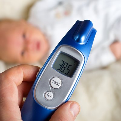 Mom checks the temperature of ill baby