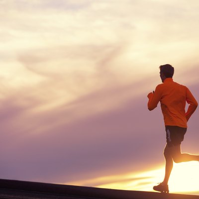 Male runner silhouette, running into sunset