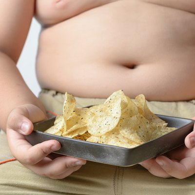 potato chip in obese fat boy hand