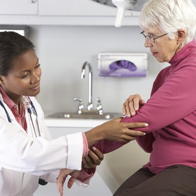 Doctor Examining Female Patient With Elbow Pain