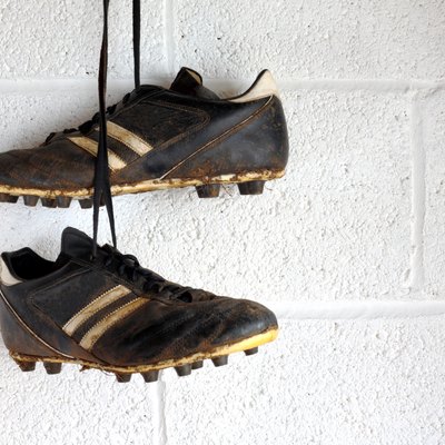 Football boots hang in a changing room