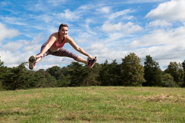Brittany does a split jump outside.