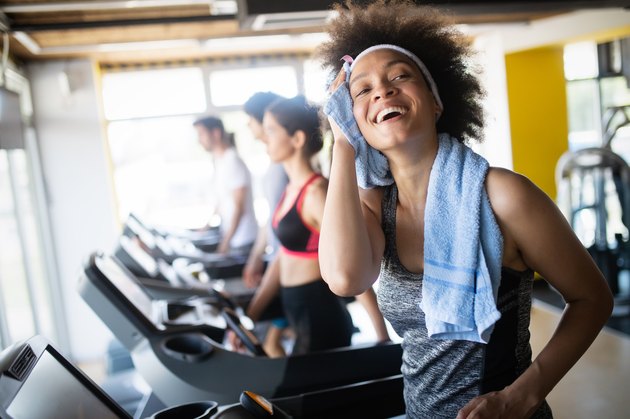 女人在跑步机上跑步，开始在健身房锻炼