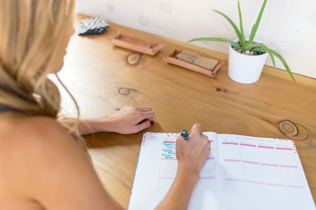 Woman writing in a journal about her health and fitness goals