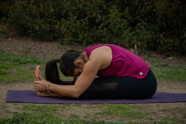 Woman performing seated forward fold.