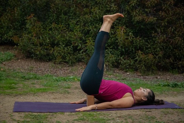 Woman performing restorative yoga posture.