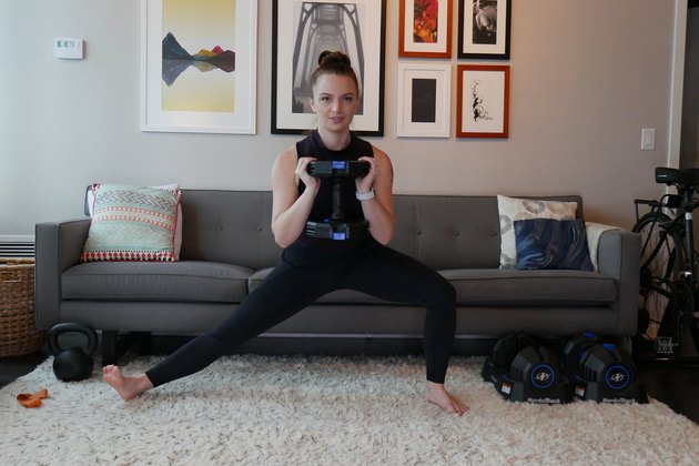 女人演示如何做一个横向蹲作为运动员力量训练锻炼的一部分”itemprop=