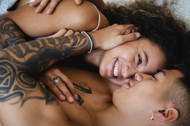 couple smiling and cuddling in bed