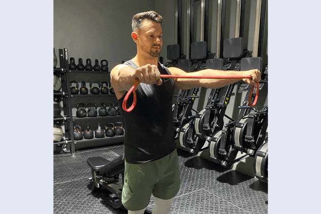 Mathew Forzaglia performing banded pull apart shoulder exercise.