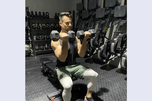 Mathew Forzaglia performing an Arnold press shoulder exercise.