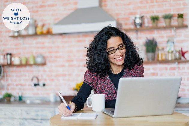 Mid adult woman working and using laptop at home