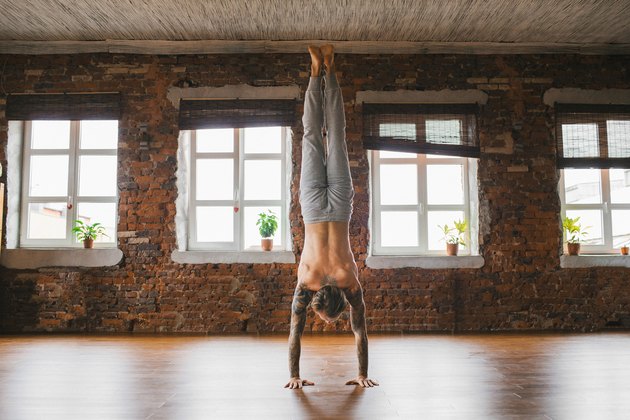 男子做倒立瑜伽姿势来保持平衡