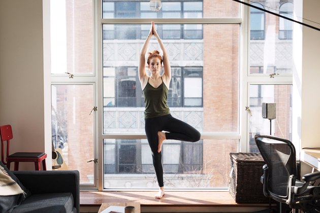 女人做树站瑜伽姿势保持平衡
