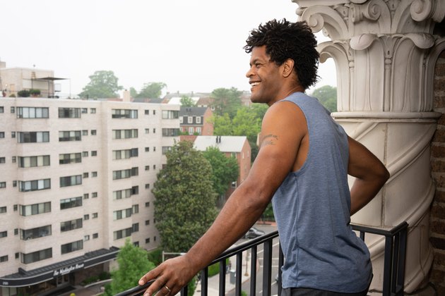 Errick stands on his balcony