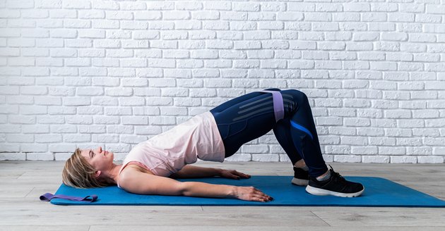 Woman using small looped resistance band.