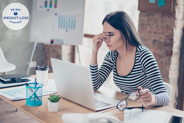 Overworked tired secretary holding spectacles and touching her nose bridge