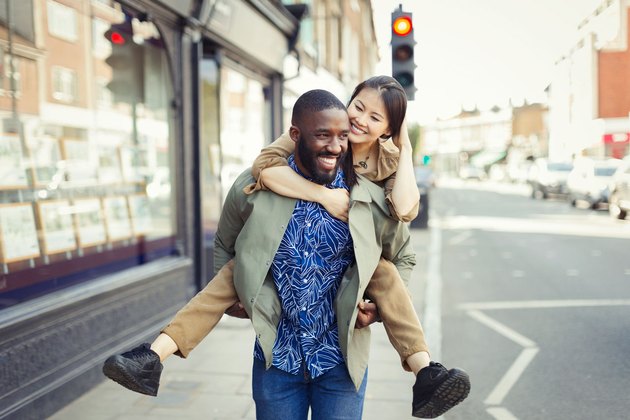 Happy Couple piggy back through city